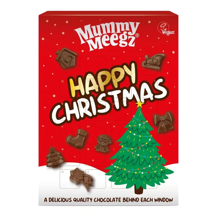 Mummy Meegz Happy Christmas chocolate advent box, featuring a red box with white and gold lettering, a green Christmas tree, and several chocolate pieces scattered.
