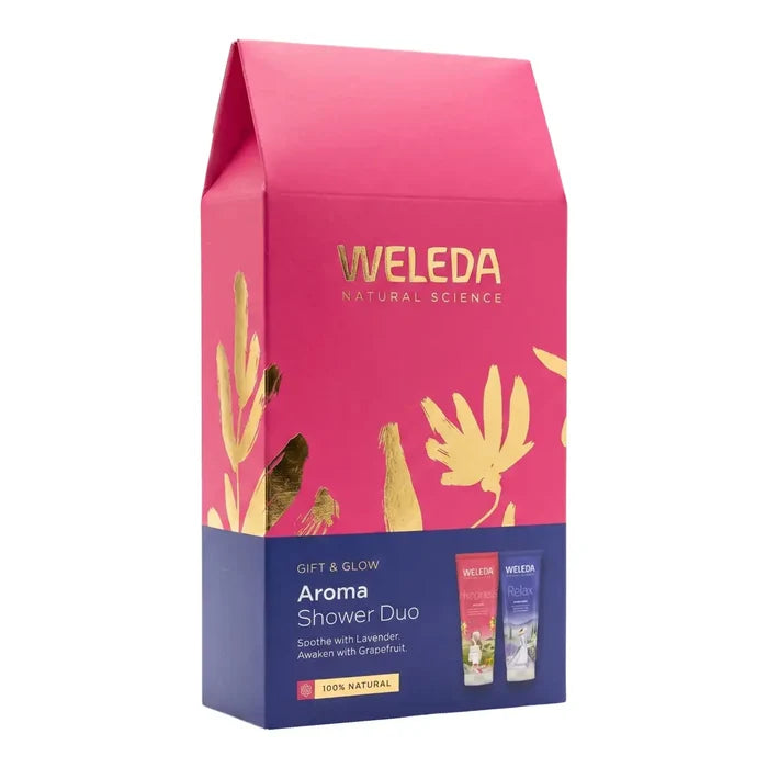Weleda Aroma Shower Duo gift box in a vibrant pink and navy blue colour scheme with gold foil accents and botanical illustrations, shown on a plain white background.
