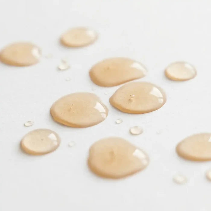 Light orange-coloured droplets on a white surface.