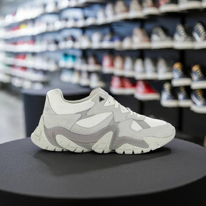 Light gray lace-up sneakers displayed with sculpted midsole and side logo patch