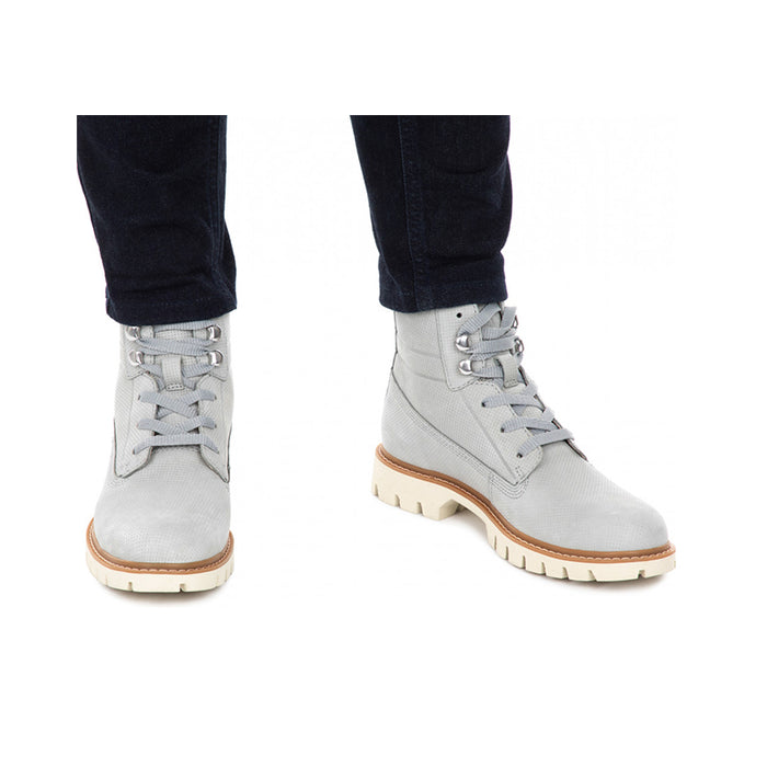 Grey ankle boots on legs, laced front and lug rubber sole