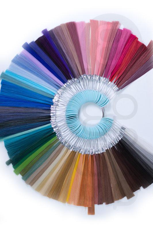 Color swatch with a circular arrangement of hair extensions in various colors on a white background.