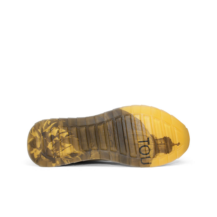 Underneath view of beige sneakers with textured gum and yellow rubber outsole