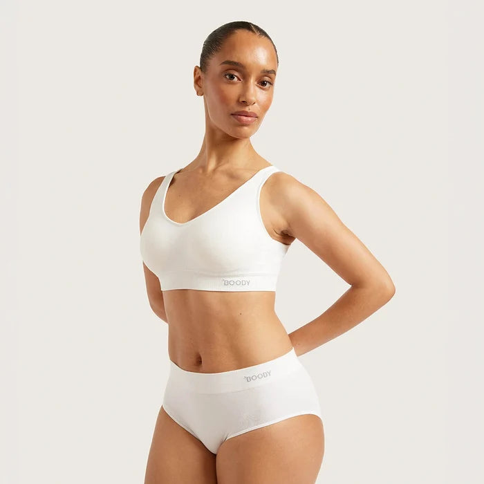 A model wearing a white Boody bralette and matching white high-waisted briefs, posed against a solid light gray studio background.
