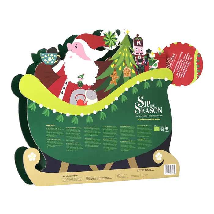 A Christmas-themed cardboard standee or sign featuring Santa Claus in a sleigh with a decorated tree, gifts, and text reading 'Sip the Season'.